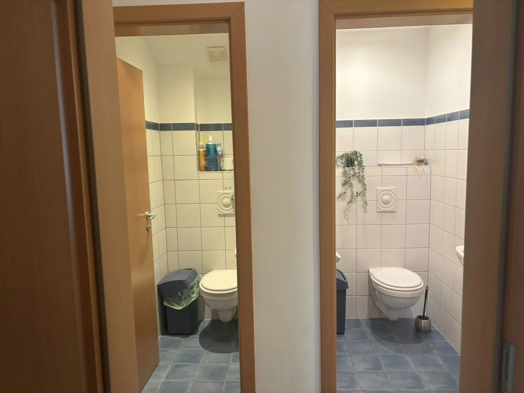 Massage treatment room with white bed, gray runner, black striped pillow, and gray circular neck support pillow. Clock mounted on wall.